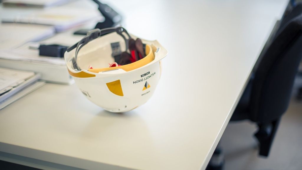 A hard hat upside down on an office desk