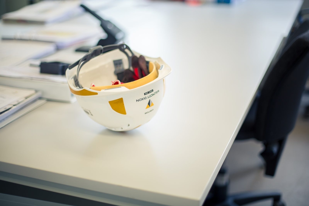 A hard hat upside down on an office desk